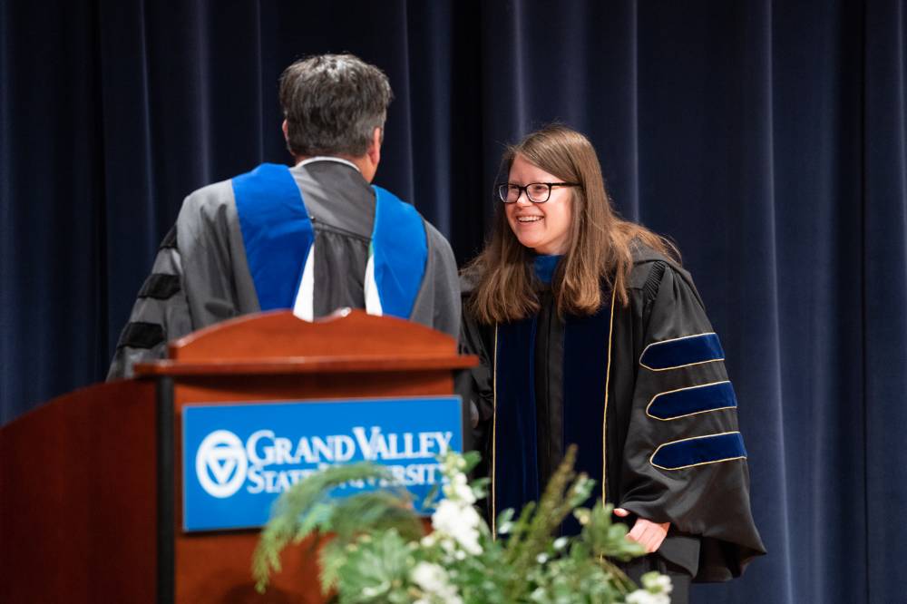 Award winner shakes hands with presenter while accepting award.